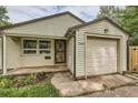 Close-up of a charming home with tidy siding, a secure front door, and attached garage at 2565 S Gaylord St, Denver, CO 80210