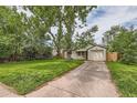 Beautiful home with lush lawn, driveway, and mature trees, exuding a welcoming atmosphere at 2565 S Gaylord St, Denver, CO 80210