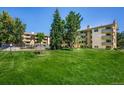 Expansive lawn area on the property with mature trees and well maintained apartment buildings at 3035 Oneal Pkwy # 35T, Boulder, CO 80301