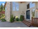 Charming exterior with stone accents, a welcoming entrance and beautiful landscaping surrounding the property at 32209 Blue Springs Dr, Evergreen, CO 80439