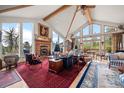 Stunning living room featuring a stone fireplace, vaulted ceilings, large windows and wood flooring at 32209 Blue Springs Dr, Evergreen, CO 80439