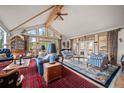 Spacious living room features vaulted ceilings, hardwood floors, and access to a covered outdoor patio at 32209 Blue Springs Dr, Evergreen, CO 80439
