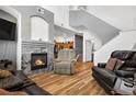 Cozy living room with a fireplace, hardwood floors, and neutral colored reclining chair at 8944 Fox Dr # 6-103, Denver, CO 80260