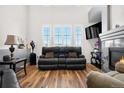 Comfortable living area with fireplace, large windows, and hardwood flooring at 8944 Fox Dr, Denver, CO 80260