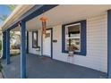 Inviting covered porch with detailed trim, potted plants, and wind chimes creates a relaxing outdoor space at 3768 S Acoma St, Englewood, CO 80110
