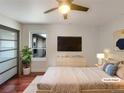 Modern bedroom features a ceiling fan, mounted TV, and minimalist decor for a serene and stylish living space at 7041 S Franklin St, Centennial, CO 80122