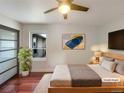 Staged primary bedroom featuring hardwood floors, a ceiling fan, and natural light at 7041 S Franklin St, Centennial, CO 80122