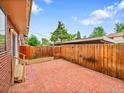 Private brick patio with wood fence, perfect for outdoor entertaining and relaxing at 12664 W Virginia Ave, Lakewood, CO 80228