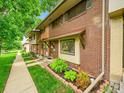 Charming two-story brick townhouse with green lawn and front garden at 12664 W Virginia Ave, Lakewood, CO 80228