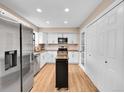 Well-lit kitchen features stainless steel appliances, white cabinets, and a mobile island for extra counter space at 12664 W Virginia Ave, Lakewood, CO 80228