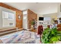 Inviting living room featuring exposed brick wall, wood floors and light-filled windows at 2224 N Humboldt St, Denver, CO 80205