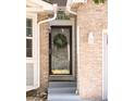 Close up of the front door, showing a decorative wreath and the home's brick facade at 5282 E 116Th Ave, Thornton, CO 80233