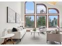 Bright living room featuring soaring ceilings, large windows, and modern furnishings at 6180 E Quincy Ave, Cherry Hills Village, CO 80111