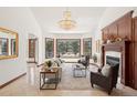 Elegant living room with large bay window, fireplace, and comfortable seating area at 6180 E Quincy Ave, Cherry Hills Village, CO 80111