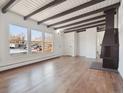 Bright living room featuring hardwood floors, exposed beams, and a fireplace at 4348 S Jason St, Englewood, CO 80110