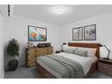 Well-lit bedroom featuring a dresser, bedside tables and modern art at 1601 Park Ave # 112, Denver, CO 80218