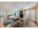 Comfortable living room with cozy fireplace, lots of seating, and sliding glass doors at 701 Harlan St # E27, Lakewood, CO 80214
