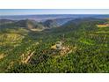 Scenic aerial view of the beautiful home nestled amongst the dense forestry at 13007 Kuehster Rd, Littleton, CO 80127