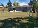 Large fenced backyard with a patio, grill, and mature trees provides a private outdoor space at 7123 Winona Ct, Westminster, CO 80030