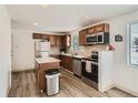 This kitchen features stainless steel appliances, wood cabinets, and modern design at 7123 Winona Ct, Westminster, CO 80030
