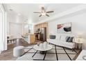 Bright open-concept living space with modern furnishings, sleek hardwood floors, and eat-in kitchen with stainless appliances at 5319 Warrior St, Frederick, CO 80504