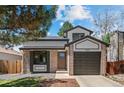 Charming two-story home featuring a brick facade, well-manicured lawn, and attached garage at 7633 Gray Way, Arvada, CO 80003