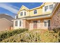 Close-up of a charming yellow home featuring brick accents, a welcoming front entrance, and a well-manicured yard at 5863 S Danube St, Aurora, CO 80015