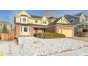 Attractive two-story yellow home with brick accents, a two-car garage, and landscaped front yard at 5863 S Danube St, Aurora, CO 80015