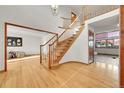 Bright foyer featuring hardwood floors, an elegant staircase, and an open layout leading into other living spaces at 5863 S Danube St, Aurora, CO 80015