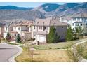 Charming two-story home showcasing red shutters, tile roof, and mountain views in a peaceful neighborhood at 2559 S Kendrick St, Lakewood, CO 80228