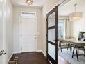 Inviting foyer with dark hardwood floors, a modern light fixture, and sliding doors at 2559 S Kendrick St, Lakewood, CO 80228