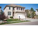 Two-story home with manicured lawn, a two-car garage, and stone accents near the entrance at 2559 S Kendrick St, Lakewood, CO 80228
