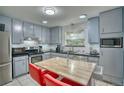 Well-lit kitchen with stainless appliances, a central table with seating, and tiled flooring at 10342 Monterey Cir, Northglenn, CO 80260