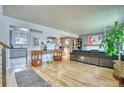 Open-concept living room boasts hardwood floors, modern decor, and seamless flow to the kitchen for easy entertaining at 10342 Monterey Cir, Northglenn, CO 80260