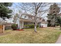 Charming two-story home with an attached garage, showcasing a well-maintained lawn at 3966 S Magnolia Way, Denver, CO 80237