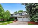 Lovely two-story home with a two-car garage, complemented by lush greenery and a well-manicured lawn at 3966 S Magnolia Way, Denver, CO 80237