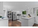 Bright kitchen featuring white cabinets, stainless steel appliances, an island and hardwood floors at 3966 S Magnolia Way, Denver, CO 80237