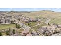 Aerial view of the neighborhood with lush green spaces, winding roads, and beautiful mountain views at 10162 Bluffmont Ln, Lone Tree, CO 80124