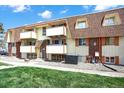 Exterior view of a condo building with balconies, manicured lawns, and visible unit number 6 at 10211 Ura_ Ln # 101, Thornton, CO 80260