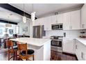 Modern kitchen with white cabinets, stainless steel appliances, quartz countertops, and eat-in island at 852 Kalamath St, Denver, CO 80204
