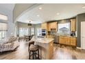 Bright kitchen boasts a center island with seating, stainless steel appliances, and hardwood floors at 29852 E 163Rd Pl, Brighton, CO 80603