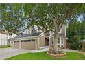 Beautiful two-story home featuring manicured lawn and mature tree, enhanced by brick and siding facade at 17051 Wellington Dr, Parker, CO 80134
