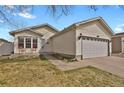 Charming single-story home featuring a two-car garage, a well-maintained lawn and a cozy front porch at 5688 Alcott St, Denver, CO 80221