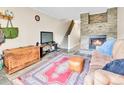 Comfortable living room with stone fireplace, wooden chest, and stairs at 2074 Oakcrest Cir, Castle Rock, CO 80104