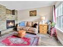 Cozy living room with stone fireplace, leather sofa, and wood-look floors at 2074 Oakcrest Cir, Castle Rock, CO 80104