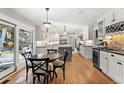 Elegant kitchen with white cabinets, modern appliances, central island, eat-in dining area, and sliding glass door to the exterior at 4071 S Dahlia St, Cherry Hills Village, CO 80113