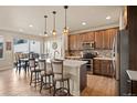 Eat-in kitchen with modern appliances, an island with barstool seating, and stylish pendant lighting at 6780 Canosa St, Denver, CO 80221