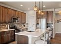 A modern eat-in kitchen with stainless steel appliances, island with barstool seating, and pendant lighting at 6780 Canosa St, Denver, CO 80221