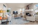 Bright and airy living room features a brick fireplace, a cozy seating arrangement, and large windows at 6780 Canosa St, Denver, CO 80221