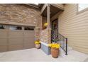 Inviting front entrance with stone accents, potted plants, and steps leading to the front door at 3418 New Haven Cir, Castle Rock, CO 80109